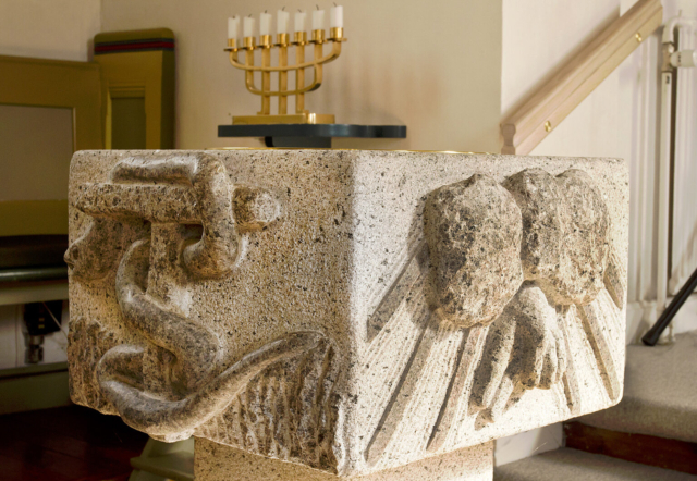 Døbefont i Badskær Kirke ved Sæby. De fire sider (relieffer) symboliserer Faderen, Sønnen, Helligånden og det evige liv
